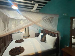 a bedroom with a bed with two donuts on it at Mbuyuni Beach Village in Jambiani