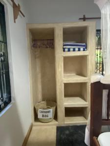 małą szafę z półkami w pokoju w obiekcie Mbuyuni Beach Village w mieście Jambiani