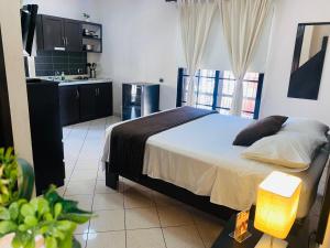 a bedroom with a large bed and a kitchen at OB Studios in Santo Domingo