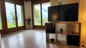 uma sala de estar com uma grande televisão de ecrã plano em Schöne Ferienwohnung in Traumlage FeWo SoloHike em Seelisberg