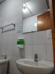 a bathroom with a sink and a mirror and a toilet at HOTEL LA REPUBLICA MANIZALES in Manizales