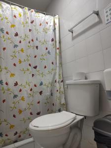 a bathroom with a toilet and a shower curtain at HOTEL LA REPUBLICA MANIZALES in Manizales