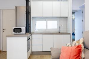 a kitchen with white cabinets and a microwave at Charming 2 Bedroom Apartment Triana Bridge By OCityzen in Seville