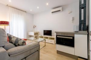 ein Wohnzimmer mit einem Sofa und einer Küche in der Unterkunft Charming 2 Bedroom Apartment Triana Bridge By Oui Seville in Sevilla