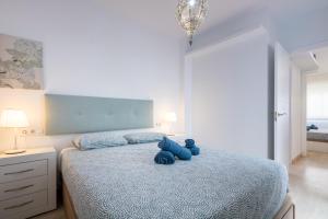 ein Schlafzimmer mit einem blauen Teddybär auf einem Bett in der Unterkunft Charming 2 Bedroom Apartment Triana Bridge By Oui Seville in Sevilla