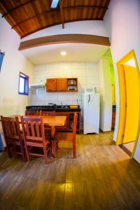 uma cozinha com uma mesa de madeira e um frigorífico em Chalés Recanto Leões de Ouro em Ubatuba