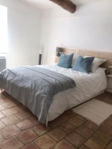 1 dormitorio con 1 cama grande con almohadas azules en Charming house village for 6 people, en Baudinard