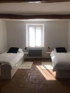 1 dormitorio con 2 camas y ventana en Charming house village for 6 people, en Baudinard