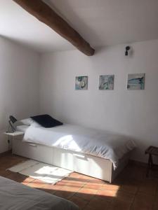 1 dormitorio con 1 cama en una pared blanca en Charming house village for 6 people, en Baudinard