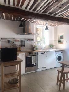 a kitchen with white appliances and a wooden ceiling at Charming house village for 6 people in Baudinard