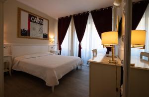 une chambre d'hôtel avec un lit et une table avec une lampe dans l'établissement Bed Bra, à Vérone