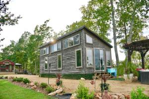 a tiny house in the middle of a yard at The Gemini-a dreamy, waterfront tiny cabin in Rogersville