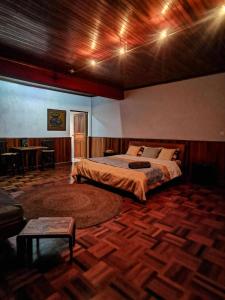 ein Schlafzimmer mit einem Bett und einem Tisch darin in der Unterkunft L'anis Etoilé in Antsirabe