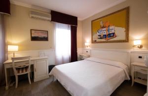 a bedroom with a bed and a desk and a window at Bed Bra in Verona