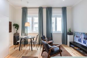 een woonkamer met een tafel en een televisie bij 150 Rivoli Apartments by LovelyStay in Porto