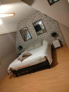 Bett in einem Zimmer mit Ziegelwand in der Unterkunft Chambres chez particuler proche du circuit in Ruaudin