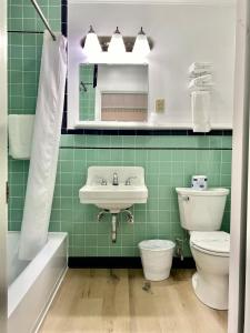 a green bathroom with a sink and a toilet at Bucksport Inn in Bucksport