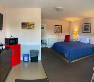 ein Schlafzimmer mit einem blauen Bett und einer roten Kommode in der Unterkunft Bucksport Inn in Bucksport