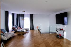 a living room with a couch and a flat screen tv at Luxury Penthouse Rzeszów in Rzeszów