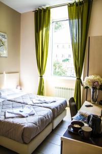 ローマにあるMosaic Central Guest Houseのベッドルーム1室(ベッド1台付)、窓(緑のカーテン付)