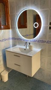 uma casa de banho com um lavatório branco e um espelho. em Appartement vue sur mer - Al Hoceima em Al Hoceïma