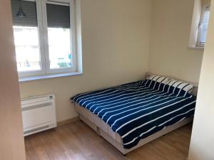 a bedroom with a bed with a blue and white striped blanket at Downtown Apartment in Kotor