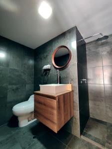 a bathroom with a sink and a toilet and a mirror at 593 Hotel Boutique Baños in Baños