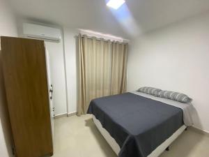 um quarto com uma cama e uma porta para uma janela em Apartamento Prox. Unievangelica 201 em Anápolis