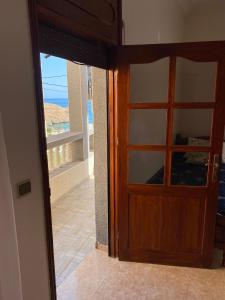 a door to a balcony with a view of the ocean at Appartement vue sur mer - Al Hoceima in Al Hoceïma