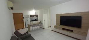a living room with a large flat screen tv at ILOA Ap inteiro - 2 suites sala cozinha in Barra de São Miguel
