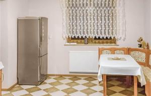 uma cozinha com uma mesa e um frigorífico num quarto em 4 Bedroom Amazing Home In Serniki 