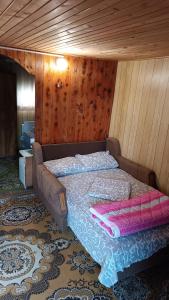 a bedroom with a bed in a room with wooden walls at Vikendica Ovčar Banja in Čačak