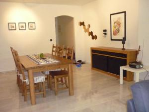 マルベーリャにあるApartment Jardinesのリビングルーム(木製テーブル、椅子付)