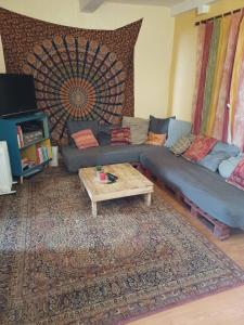 un soggiorno con divano blu e tavolo di Appartement atypique centre ville Thuir a Thuir