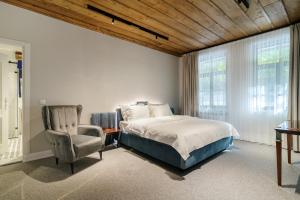 a bedroom with a bed and a chair at Carpe Diem in Sladka Voda