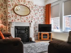 sala de estar con TV y chimenea en Saltburn Town House en Saltburn-by-the-Sea