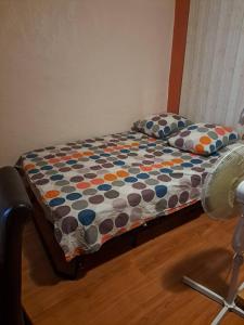 un letto con coperta a pois e ventilatore di Appartement atypique centre ville Thuir a Thuir