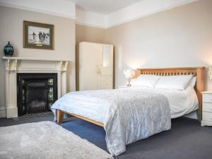 1 dormitorio con 1 cama y chimenea en Saltburn Town House en Saltburn-by-the-Sea