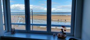 ein Fenster mit Blick auf den Strand und das Meer in der Unterkunft Vakantie-appartement La Régence @ Oostende in Ostende