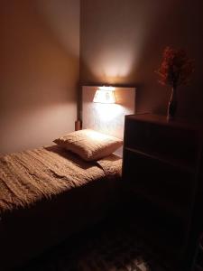 1 dormitorio con 1 cama con lámpara. en Nirvana Hermosa habitación individual e independiente en Guatemala