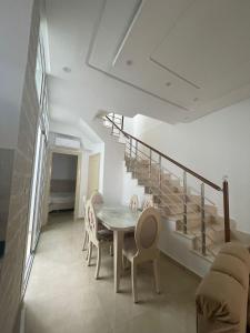 a dining room with a table and chairs and stairs at La maison du Jasmin in Mahdia +4 photos