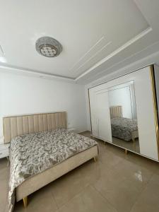 1 dormitorio con cama y espejo en La maison du Jasmin en Mahdia