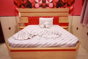 uma cama num quarto com cabeceira vermelha em Motel Vison (Próximo GRU Aeroporto) em Guarulhos