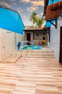 un patio de azulejos con piscina y una casa en Casa com Piscina na Praia do Francês, en Marechal Deodoro