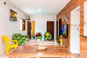 sala de estar con mesa de madera y sillas en Casa com Piscina na Praia do Francês, en Marechal Deodoro