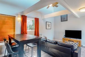 a dining room with a table and chairs and a television at Singing Winds in Port Orford