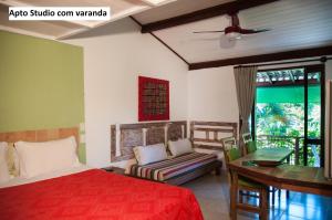 Casa Verde Apart Apartamentos com cozinha في برايا دو فورتي: غرفة نوم بها سرير وأريكة ونافذة