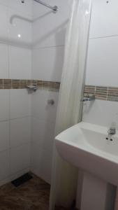 a white bathroom with a sink and a shower at Apartamentos Freddy's Tours in Santa Marta