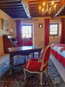 1 dormitorio con mesa, sillas y 1 cama en Junior Suite Triple PMR Résidentielle avec cuisine au Manoir de Mathan à Crépon 5mn d'Arromanches et 10 mn de Bayeux, en Crépon