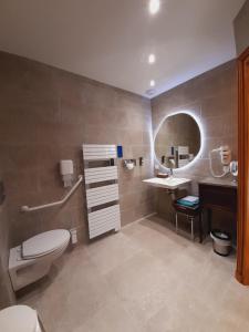 y baño con aseo, lavabo y espejo. en Junior Suite Triple PMR Résidentielle avec cuisine au Manoir de Mathan à Crépon 5mn d'Arromanches et 10 mn de Bayeux, en Crépon